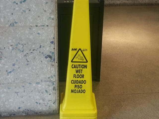 Yellow Caution wet floor sign on supermarket floor.