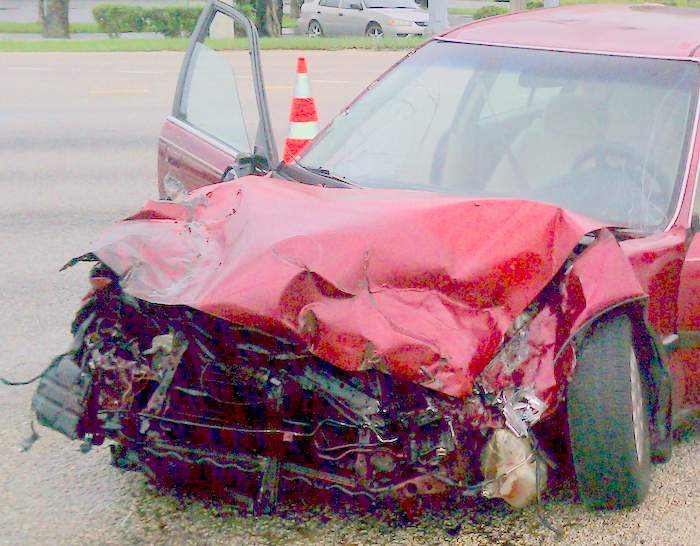 Front of car damaged in truck wreck.