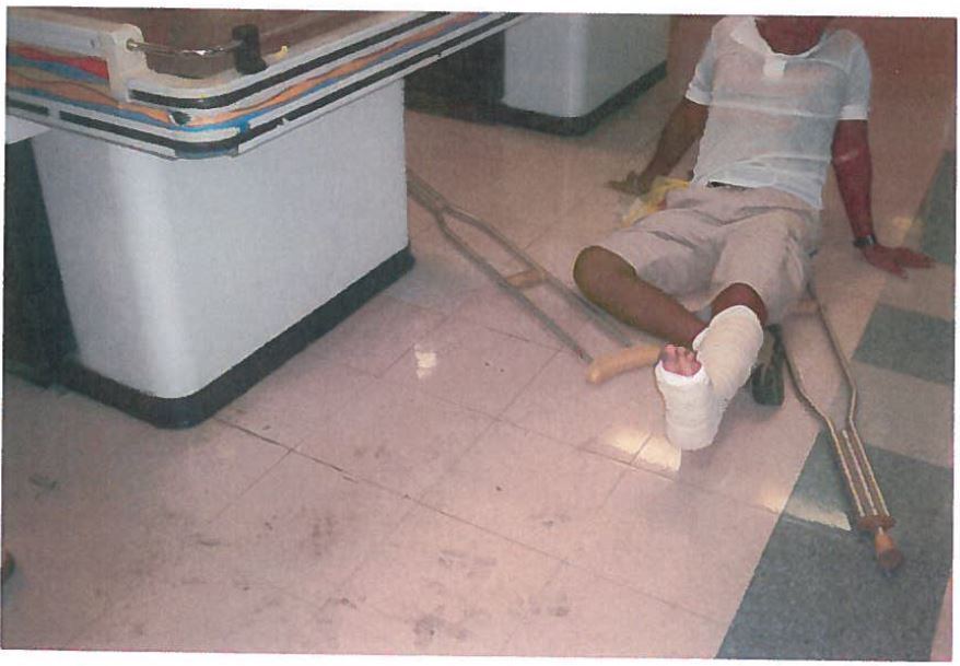 supermarket man with crutches on floor next to dirty spot 