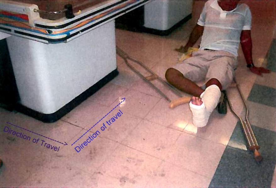 Man with crutches sitting on dirty floor after slip and fall at a store