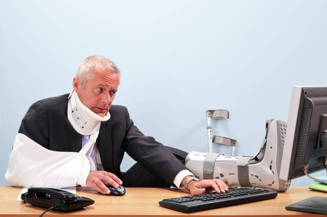 Man at work with boot on foot, arm in sling ,wearing neck collar, arm crutches