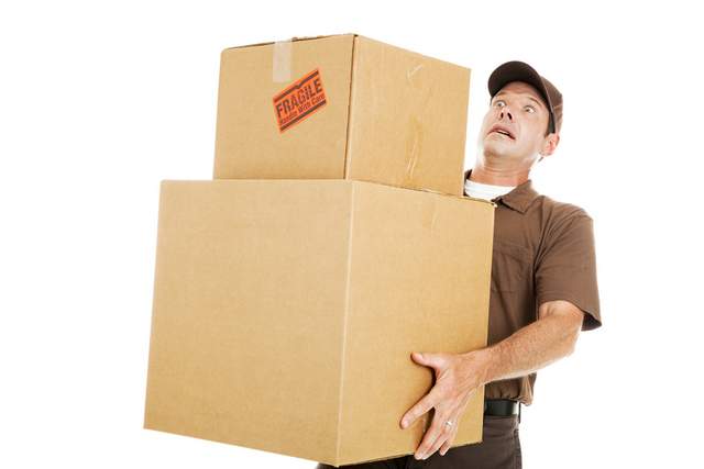 Worker holding boxes about to fall.