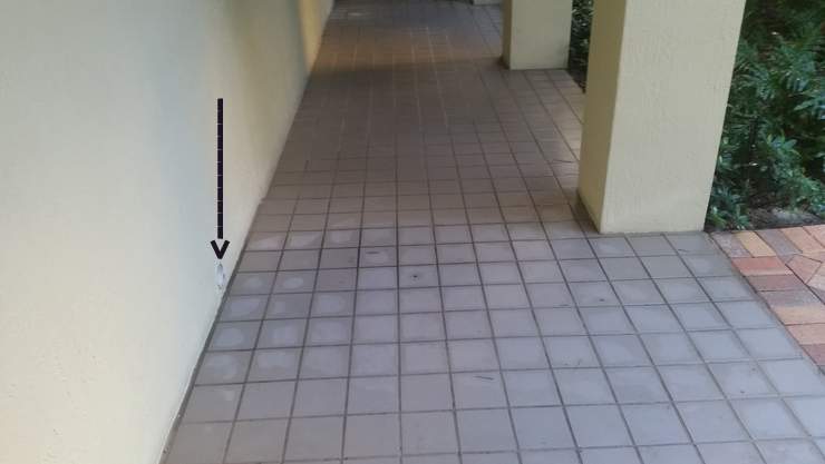Pipe in the wall shoots water onto the walkway. Pinecrest, Miami-Dade County, Florida.