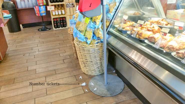 Slip and fall on number tickets on floor next to deli in Miami, Florida Supermarket.
