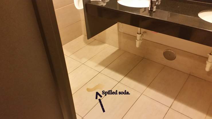 Spilled soda on a bathroom floor at an office building is a hazard. Coral Gables, Miami-Dade County, Florida.