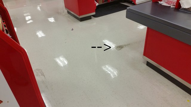 black substance on the floor near a store checkout counter.
