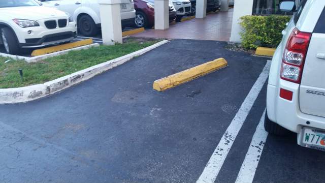 Wheel stop in middle of parking space. Miami-Dade County strip mall. 