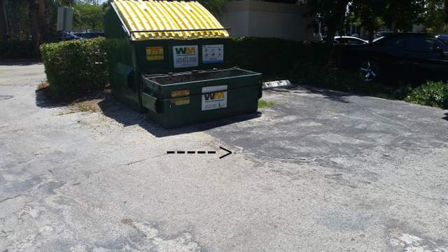 rod sticking out of the ground in office building parking lot 