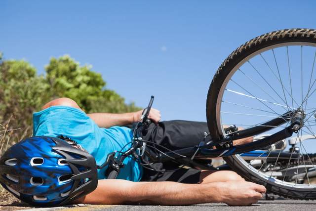 Cyclist lying on the road after an accident 