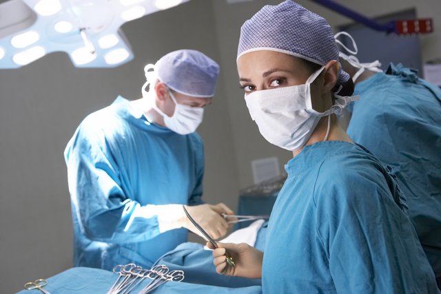 Doctors performing surgery in operating room.