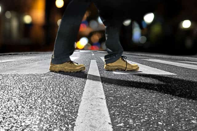 Pedestrian crossing street late at night