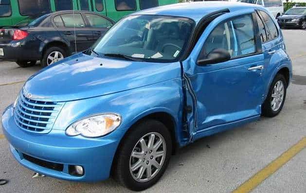 Damage to driver's side car door after another car hits the door and the pedestrian who was putting a parking ticket receipt inside his car.