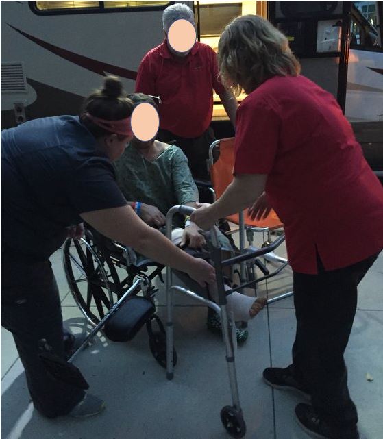 claimant being taken from wheelchair to walker to get on ambulance