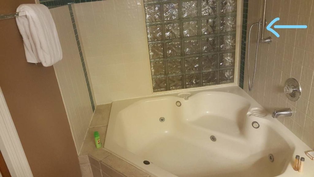 Blue arrow pointed to shower fixture in bathtub