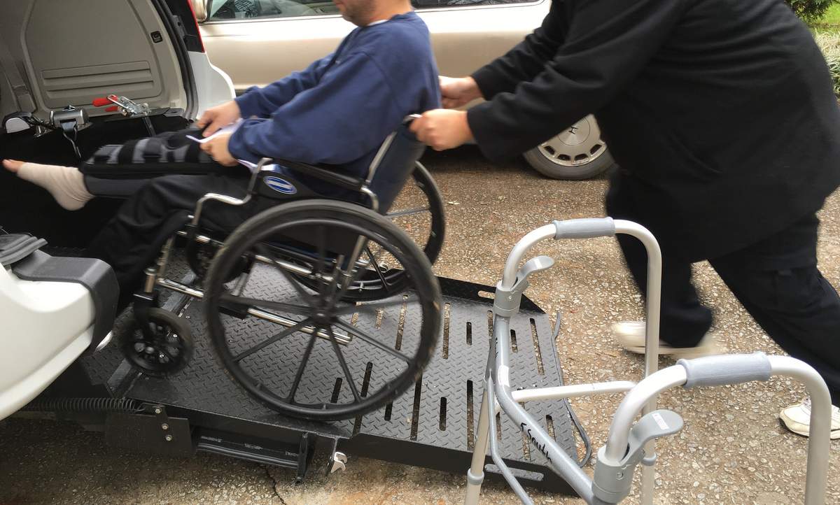 client in wheel being placed onto ramp of van transport